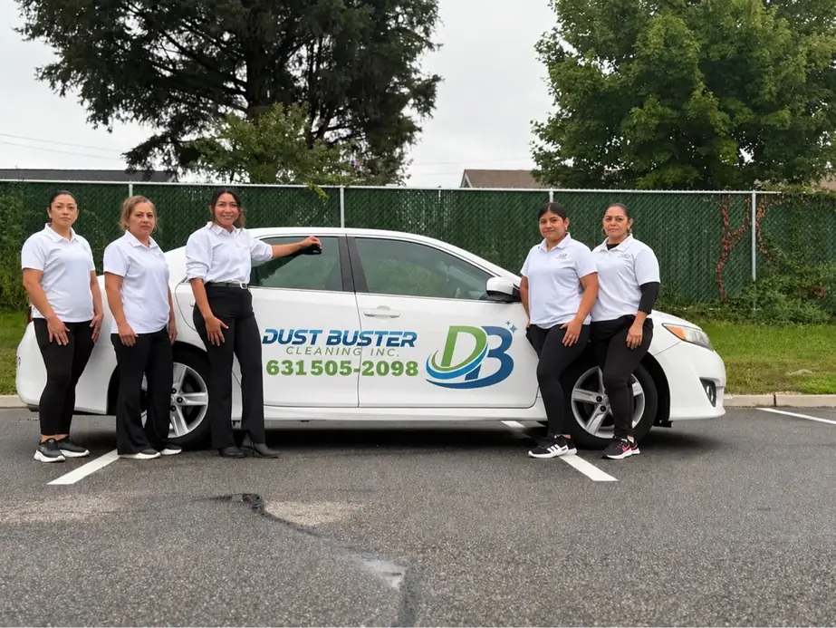 Five Dust Buster staff in white logo polos beside the white company car lettered with the DB logo and 631-505-2098